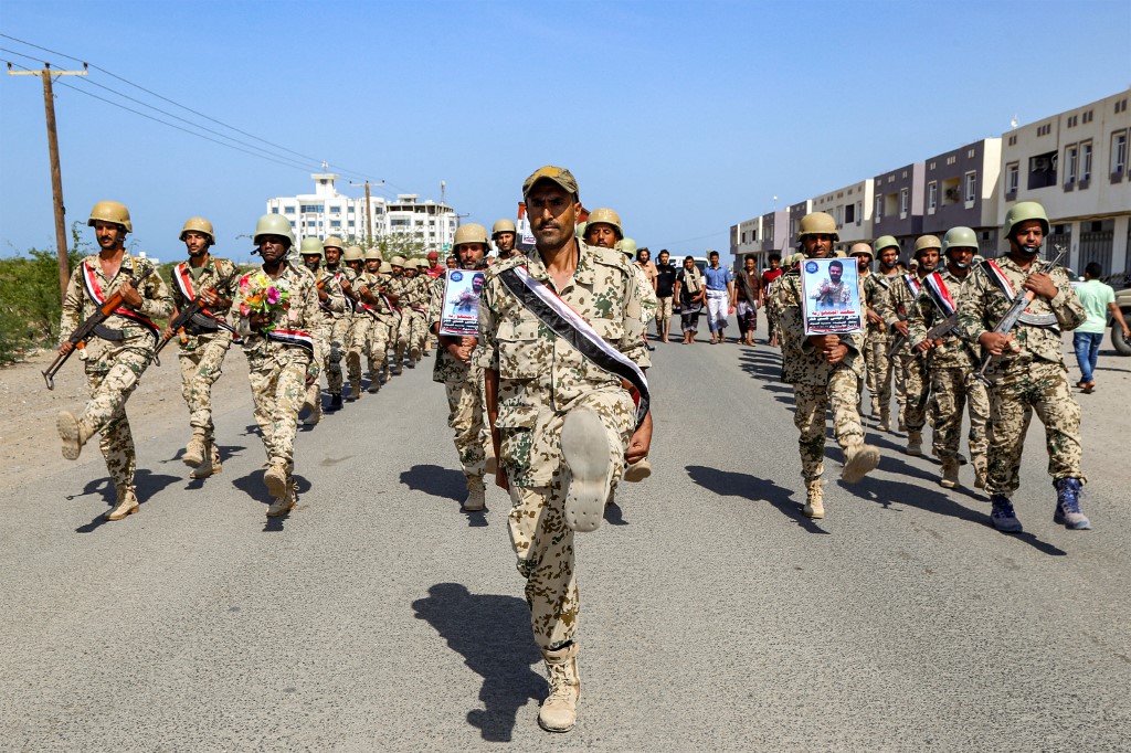 Fighters loyal to Yemen’s Saudi-backed government march during a mass funeral for fellow fighters in Hodeida on 31 October 2022 (AFP)